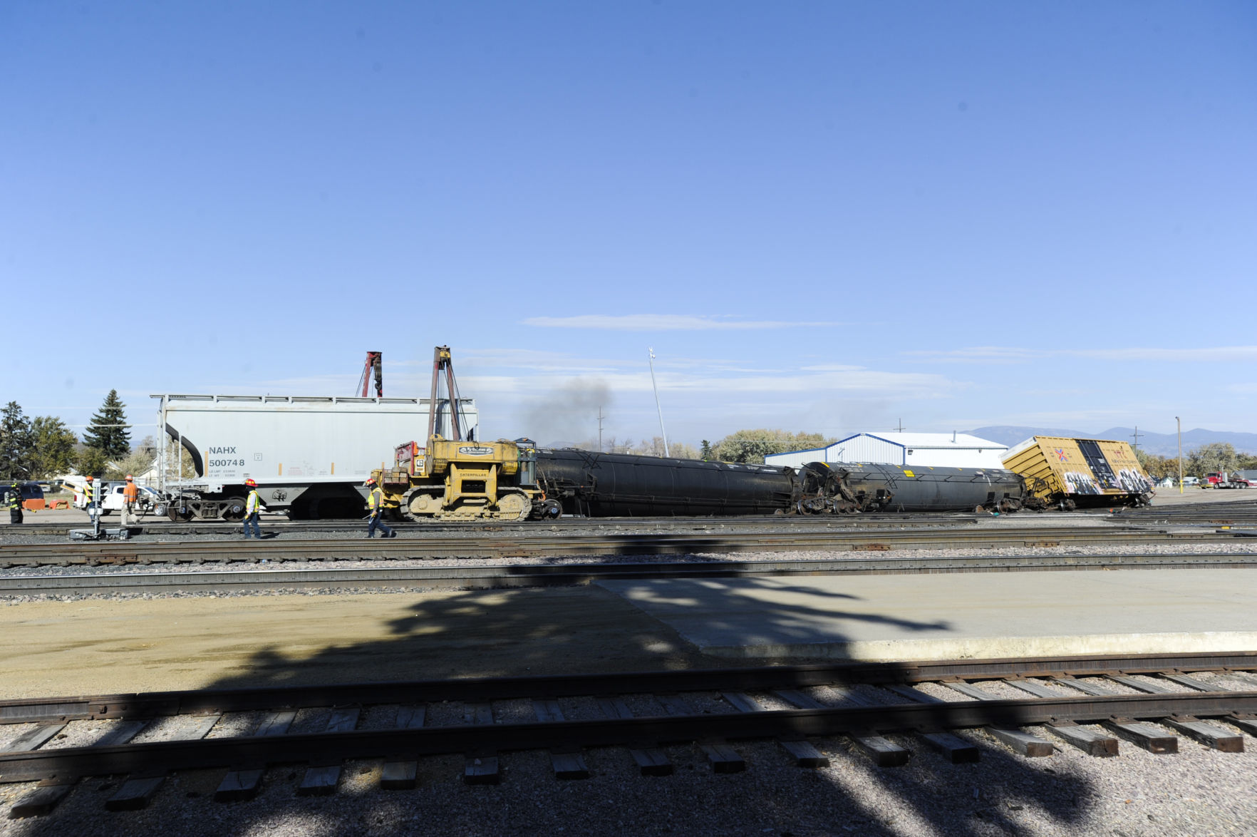 Montana Rail Link workers work to re-rail several train cars